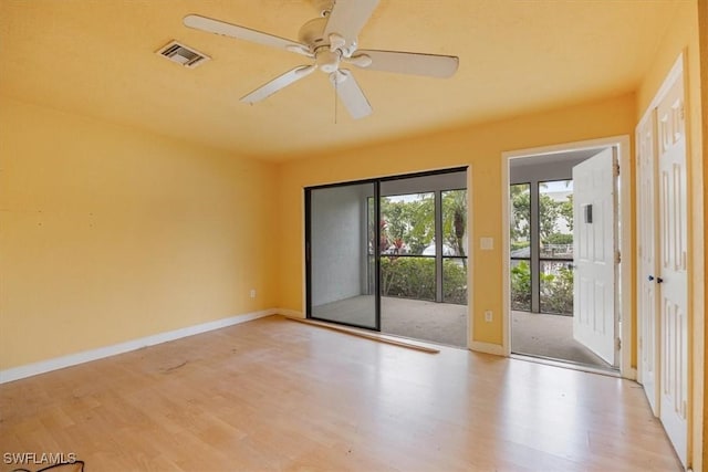 empty room with ceiling fan and light hardwood / wood-style flooring