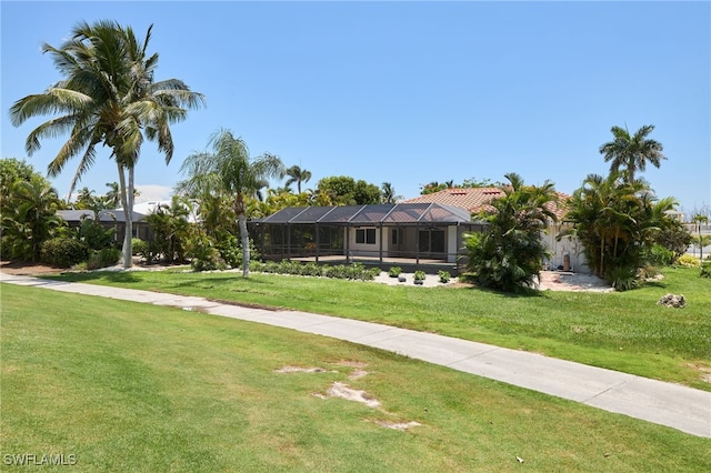 view of front of property featuring a front lawn and glass enclosure