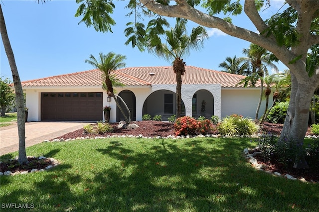 mediterranean / spanish-style home featuring a garage and a front yard