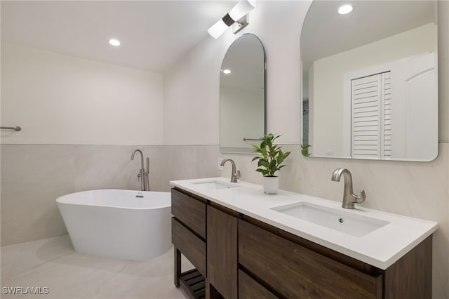 bathroom with vanity, tile walls, and a washtub