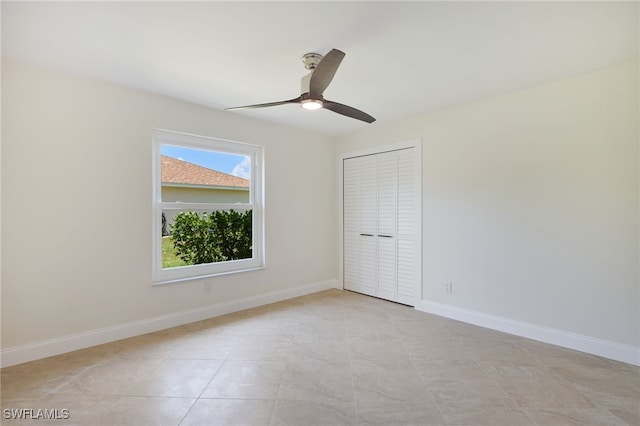 tiled empty room featuring ceiling fan