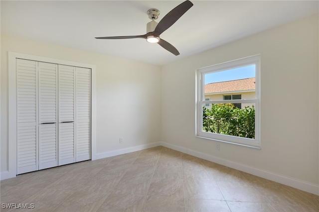 unfurnished bedroom featuring ceiling fan, light tile patterned flooring, and a closet