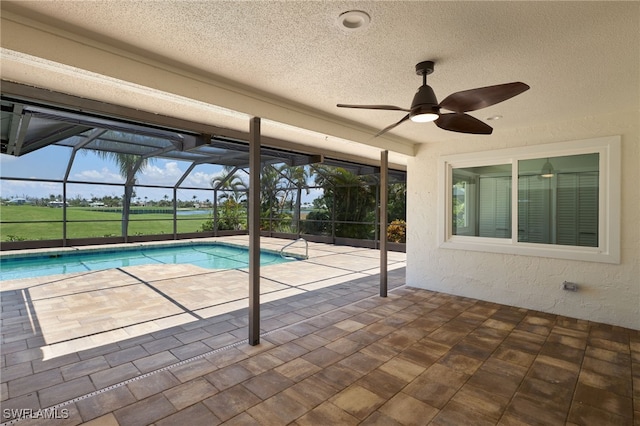 view of pool with a lanai, ceiling fan, and a patio