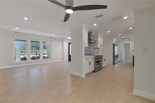 kitchen featuring ceiling fan, decorative backsplash, appliances with stainless steel finishes, white cabinets, and wall chimney exhaust hood