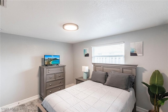 bedroom featuring a textured ceiling and light wood-type flooring