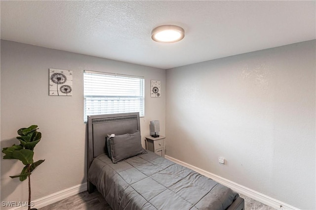 bedroom with wood-type flooring and a textured ceiling