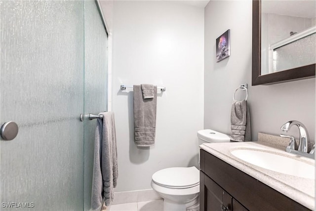 bathroom with tile patterned flooring, vanity, toilet, and walk in shower