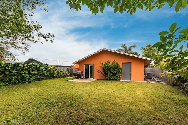 back of house featuring a yard, central AC unit, and a patio area