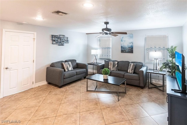 tiled living room with ceiling fan and a textured ceiling