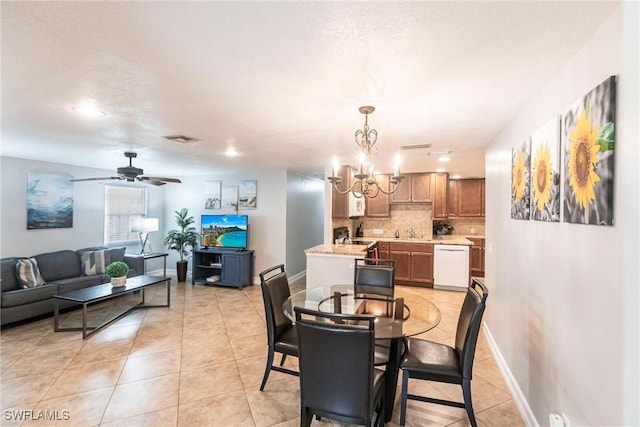 tiled dining room featuring sink and ceiling fan with notable chandelier