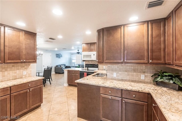 kitchen with light tile patterned floors, ceiling fan, backsplash, range with electric stovetop, and light stone countertops