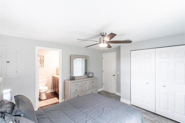 bedroom with electric panel, a closet, ceiling fan, and ensuite bathroom