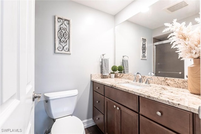 bathroom featuring vanity, hardwood / wood-style flooring, a shower with door, and toilet