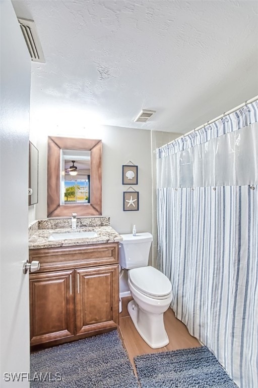 bathroom with toilet, hardwood / wood-style floors, and vanity