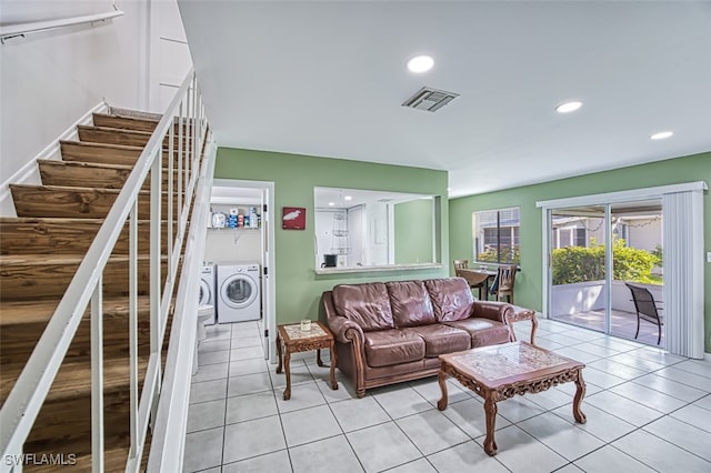 tiled living room featuring washer and dryer