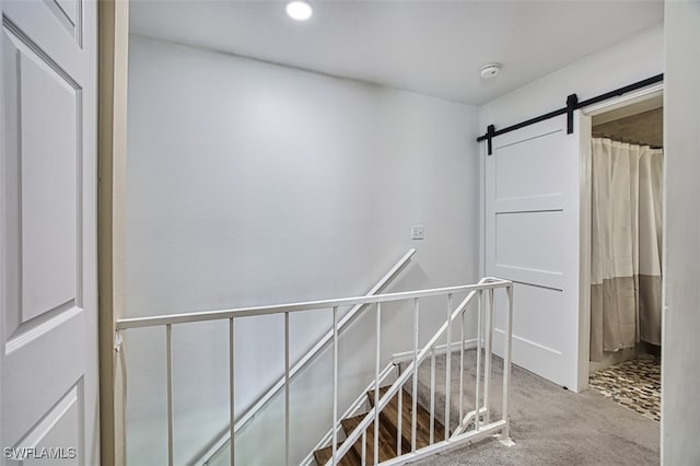 corridor featuring carpet and a barn door