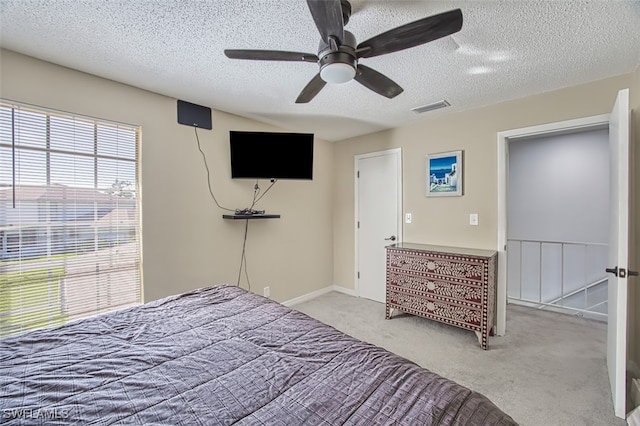 unfurnished bedroom with ceiling fan, a textured ceiling, and carpet flooring