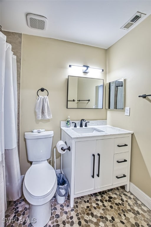 bathroom with curtained shower, toilet, and vanity