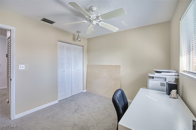 unfurnished office featuring ceiling fan and light colored carpet