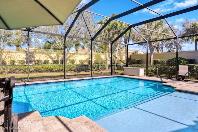 view of pool with a patio and glass enclosure