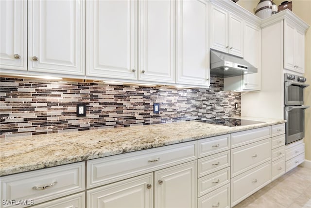 kitchen with light stone counters, white cabinets, black electric cooktop, and double oven