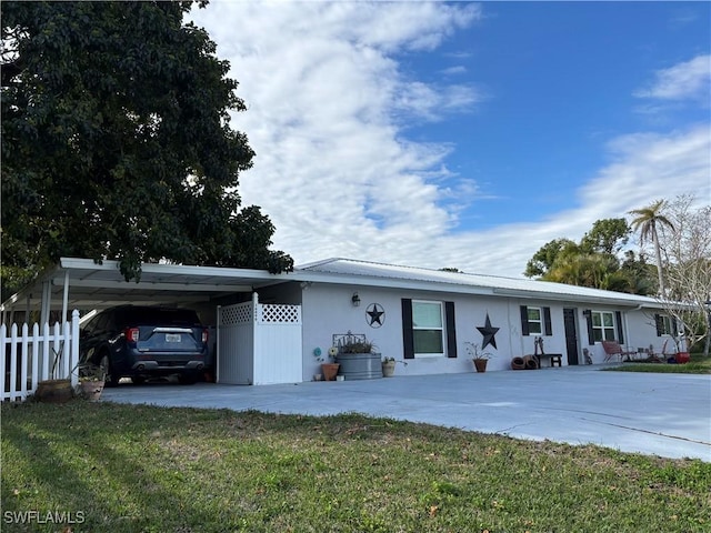 ranch-style home featuring a front yard and a carport