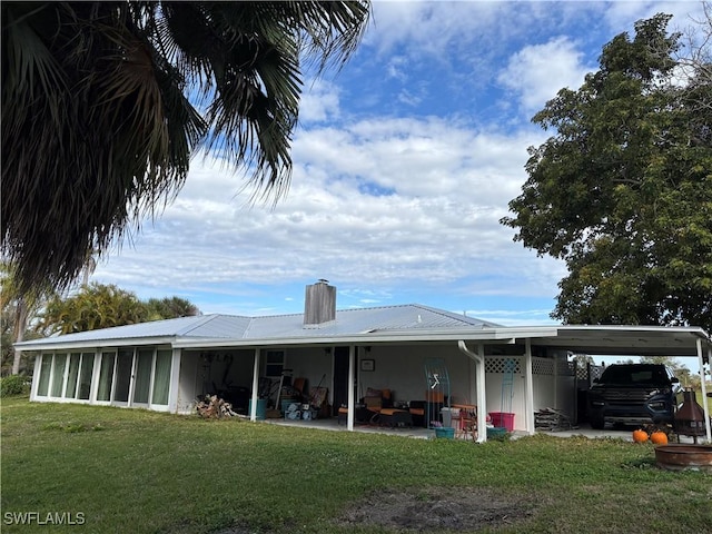 back of house with a lawn and a carport