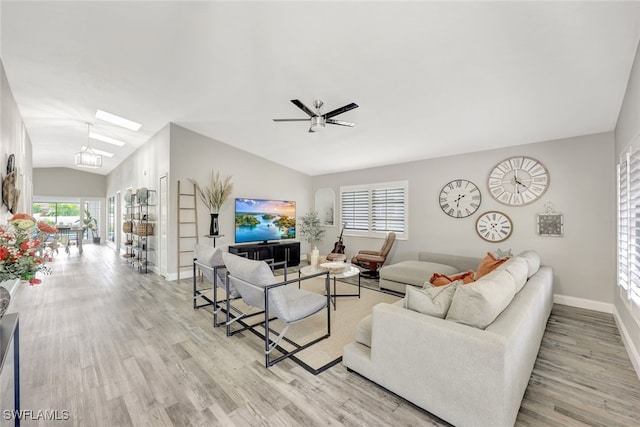 738 101st Ave N, Naples, FL 34108 - living area featuring light wood-style floors, lofted ceiling, a skylight, a ceiling fan, and baseboards