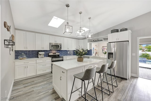 738 101st Ave N, Naples, FL 34108 - kitchen featuring appliances with stainless steel finishes, a sink, a skylight, vaulted ceiling, and backsplash