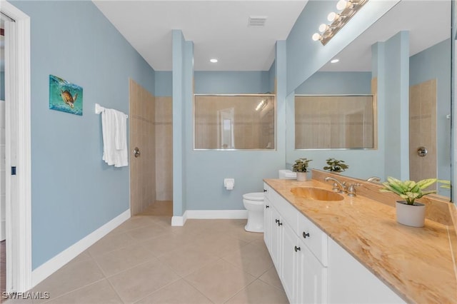 bathroom with toilet, vanity, tile patterned floors, and a tile shower