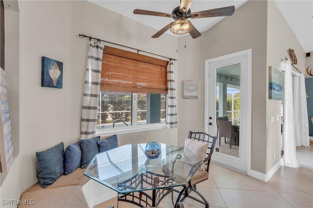 tiled dining space featuring ceiling fan and vaulted ceiling