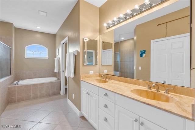 bathroom with plus walk in shower, tile patterned floors, and vanity