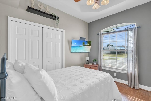 bedroom with ceiling fan, wood-type flooring, and a closet