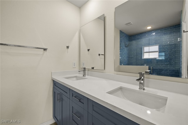 bathroom with vanity and a tile shower