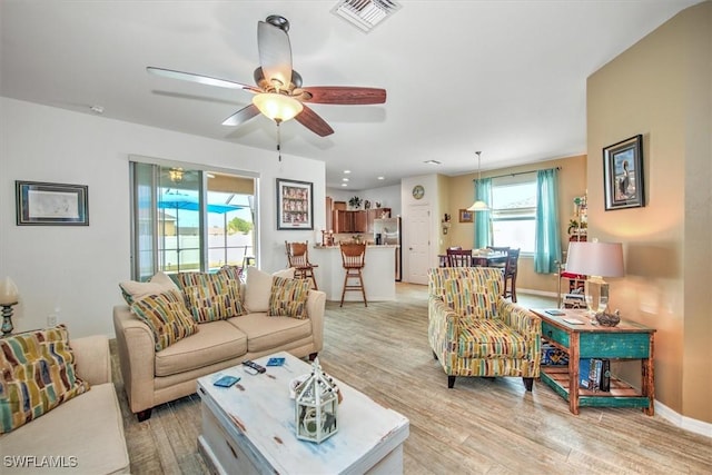 living room with ceiling fan and light hardwood / wood-style floors