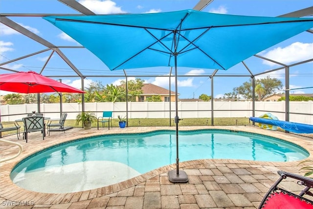 view of swimming pool featuring glass enclosure and a patio area