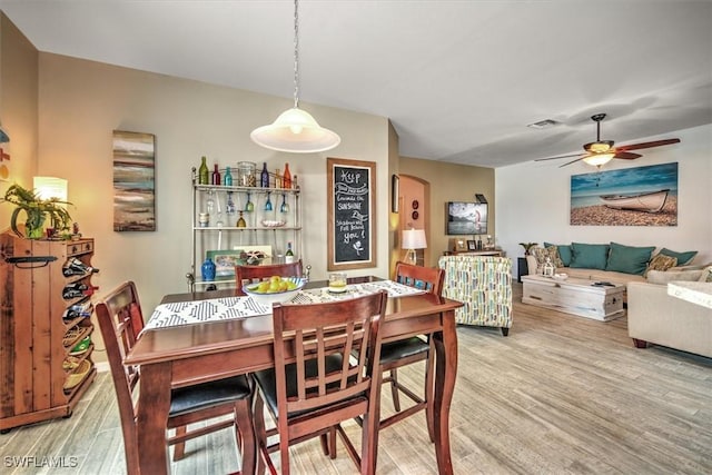 dining space with ceiling fan and hardwood / wood-style flooring