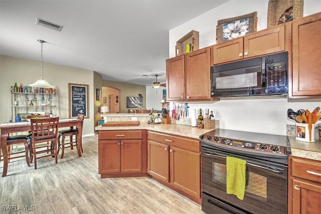 kitchen featuring ceiling fan, pendant lighting, black appliances, kitchen peninsula, and light hardwood / wood-style flooring