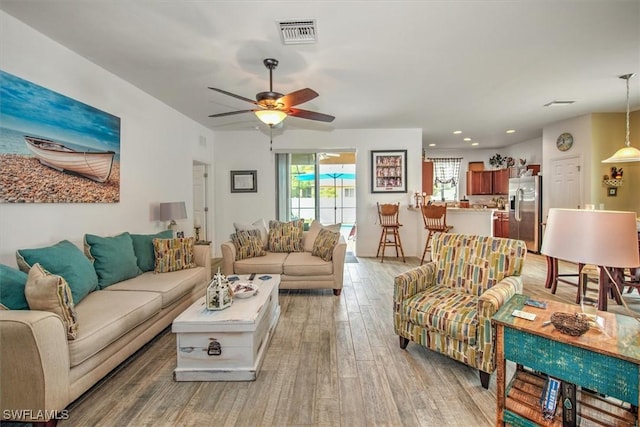 living room featuring ceiling fan and wood-type flooring