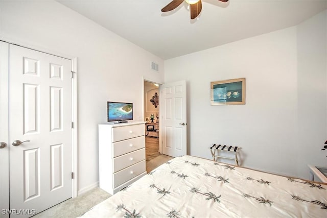 carpeted bedroom with ceiling fan and a closet