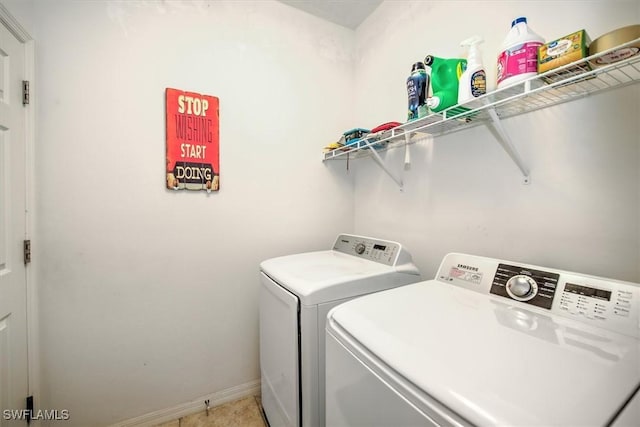 laundry area with light tile patterned floors and washing machine and clothes dryer