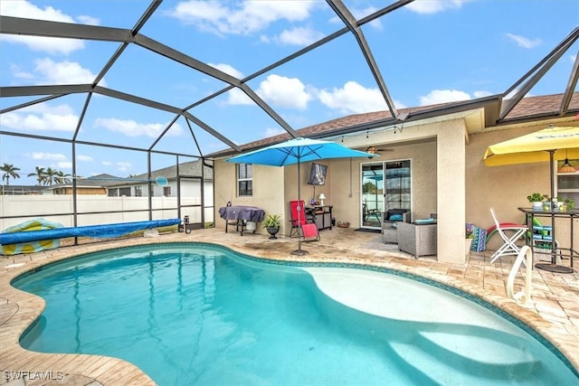 view of pool featuring glass enclosure and a patio area