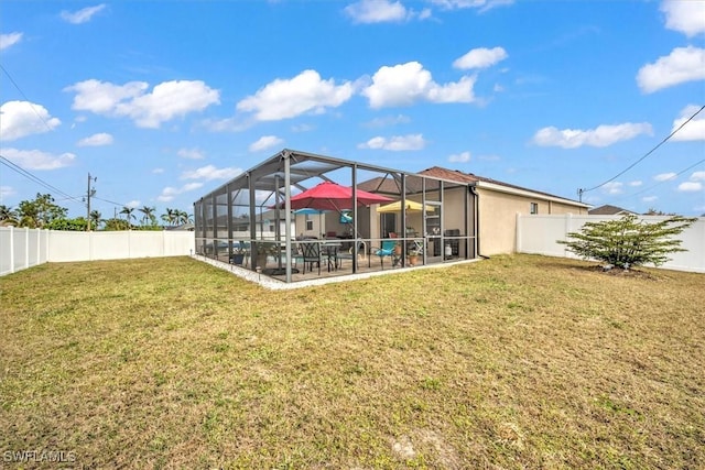 back of house featuring glass enclosure, a lawn, and a patio