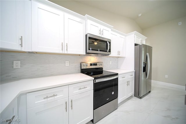 kitchen featuring lofted ceiling, ceiling fan, tasteful backsplash, white cabinetry, and stainless steel appliances