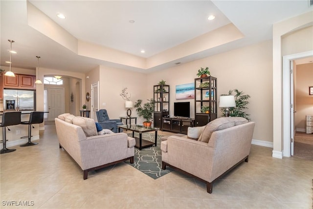 tiled living room with a tray ceiling