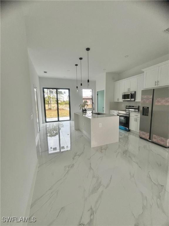 kitchen with white cabinets, decorative light fixtures, stainless steel appliances, sink, and a center island with sink