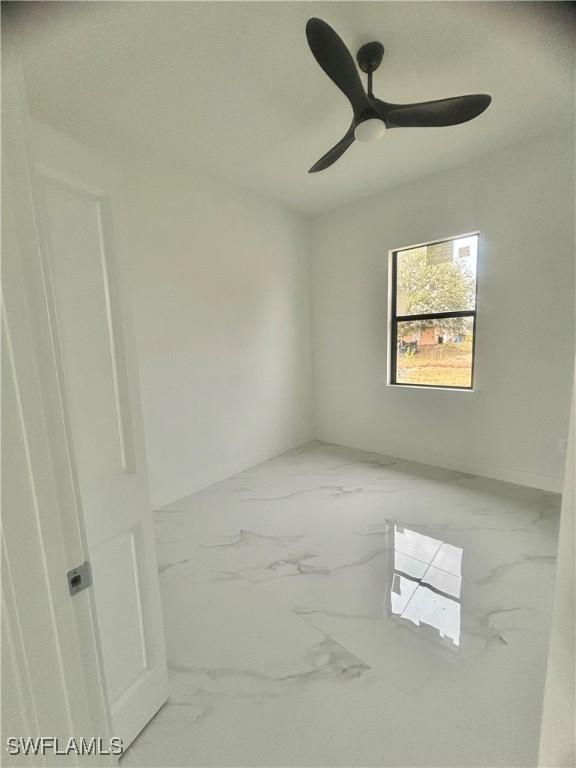 3204 20th St SW, Lehigh Acres, FL 33976 - empty room featuring marble finish floors and a ceiling fan