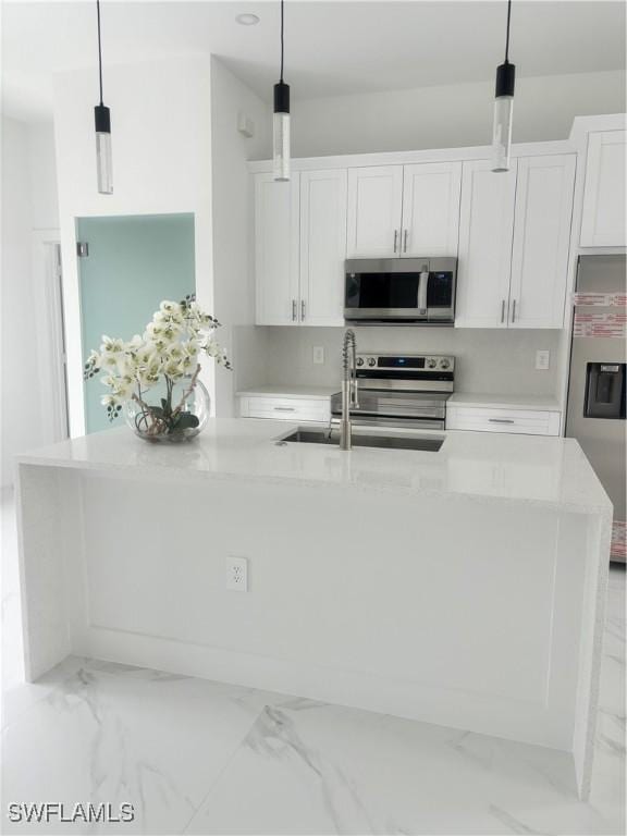 kitchen with white cabinetry, a kitchen island with sink, stainless steel appliances, and pendant lighting