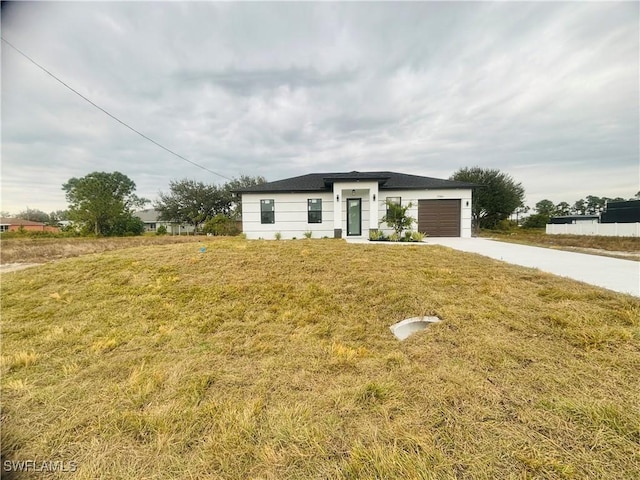 view of front of property featuring a front yard and a garage