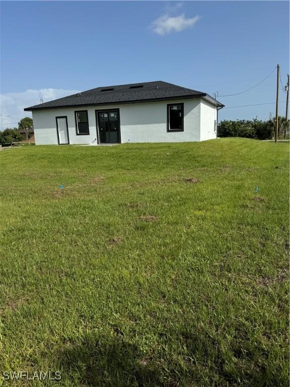 3204 20th St SW, Lehigh Acres, FL 33976 - back of property featuring a yard and stucco siding
